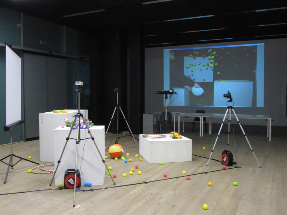 Camera and white plinths and balls in studio