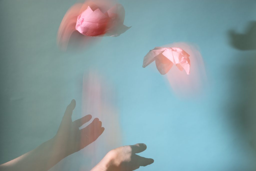 Hands throwing paper flowers in the air.