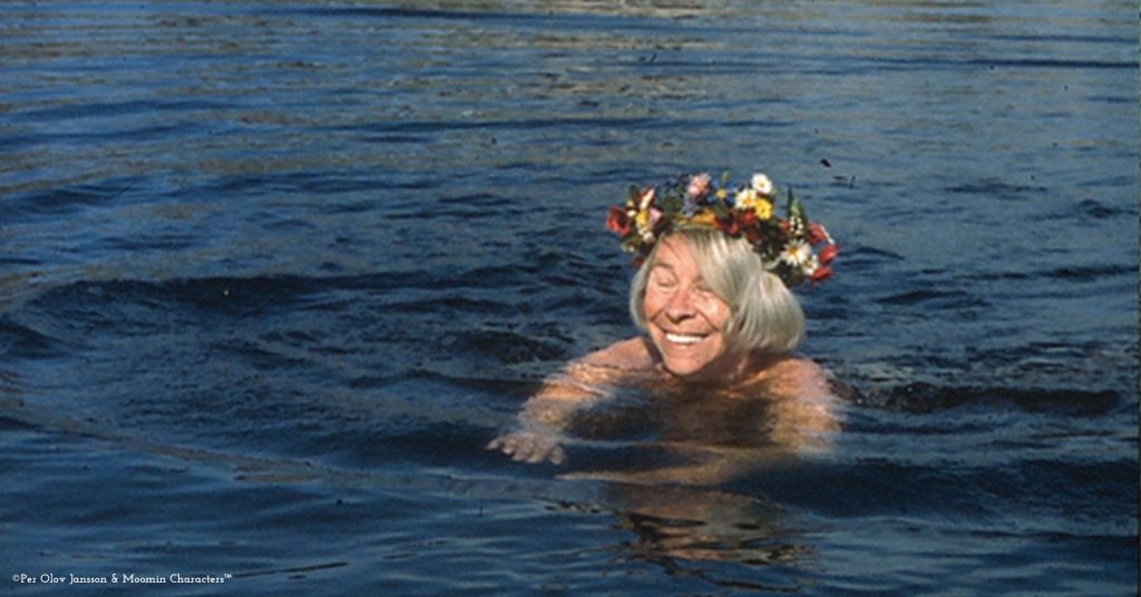 Woman swimming in the sea with a crown of flowers.